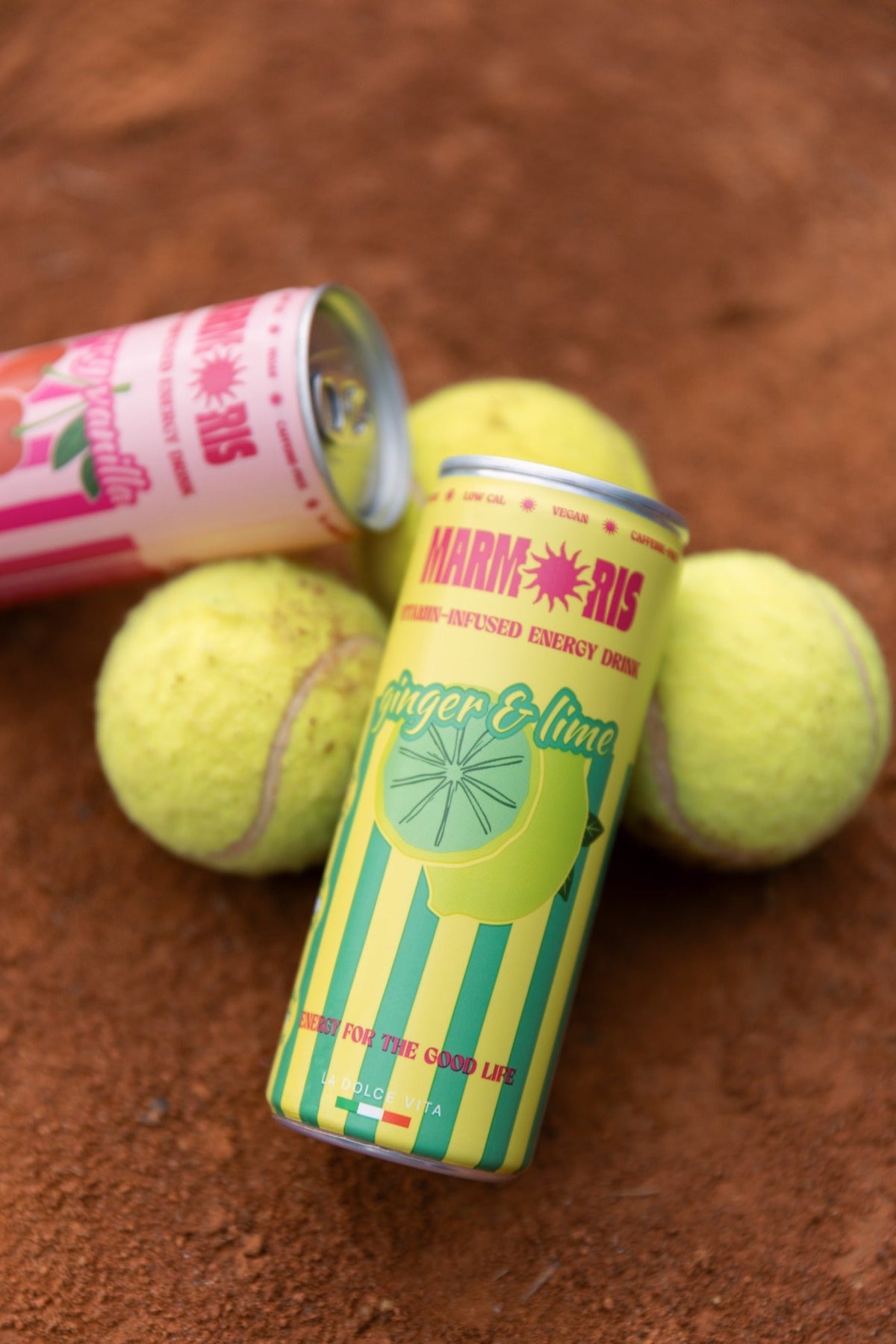 Marmoris Ginger & Lime nella confezione originale gialla e verde su un campo da tennis
